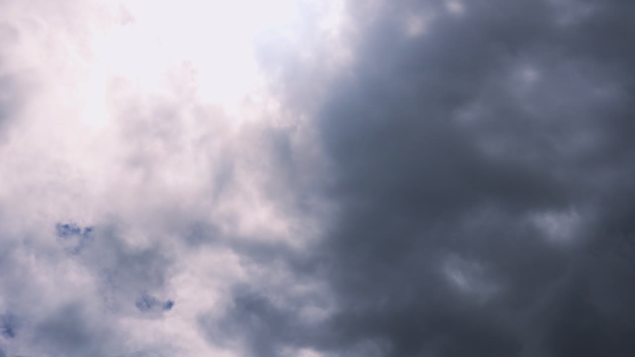 Ominous Dark Storm Clouds Moving Over White Cloudy Background Timelapse. Natural Sky Background Wallpaper Footage.