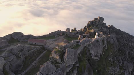 Close-up-of-Castelo-de-Monsanto-during-a-misty-morning-at-Portugal,-aerial