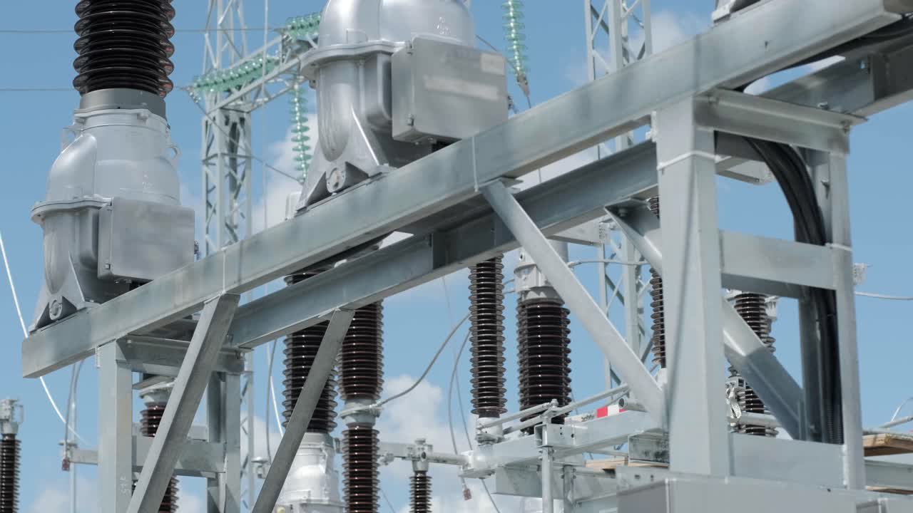 muchos aislantes eléctricos de alto voltaje en la subestación de energía contra un fondo de cielo azul