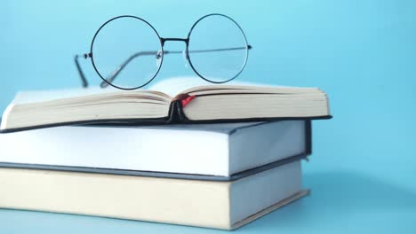 books and glasses on a blue background