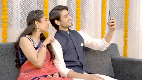 una pareja india tomando selfies