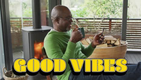 animation of good vibes text over smiling senior african american man using smartphone