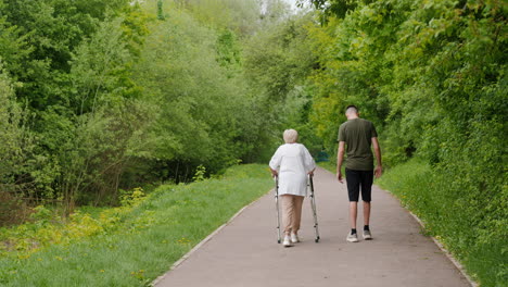 elderly person walking with assistance from a young person