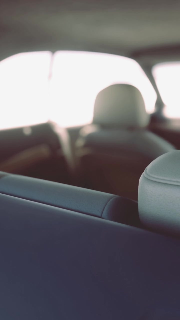 Vista del interior de un coche con asientos vacíos y luz solar intensa en el exterior