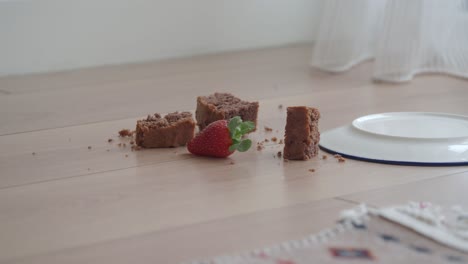 broken chocolate cake and strawberry on floor