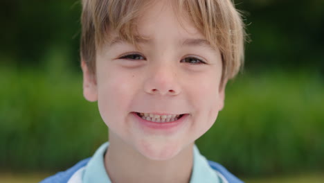 portrait happy little boy smiling with playful excitement looking at camera enjoying childhood fun in sunny park 4k footage