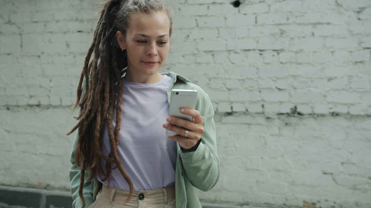 Young woman using a phone outside