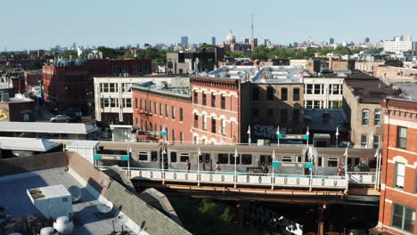 a slow aerial reveal of the chicago skyline beyond train station as a rail trail departs