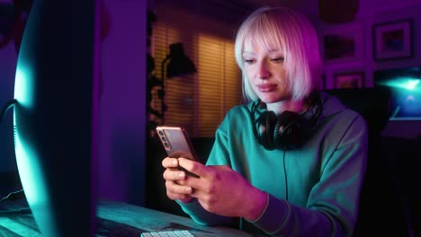 young caucasian woman browsing mobile phone while a break during playing game at night on desktop p