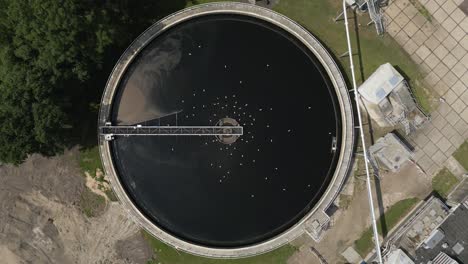 top-down drone footage of a circular wastewater treatment tank with mechanical arm, part of the water infrastructure system near volendam in the netherlands. vital for sustainable water purification