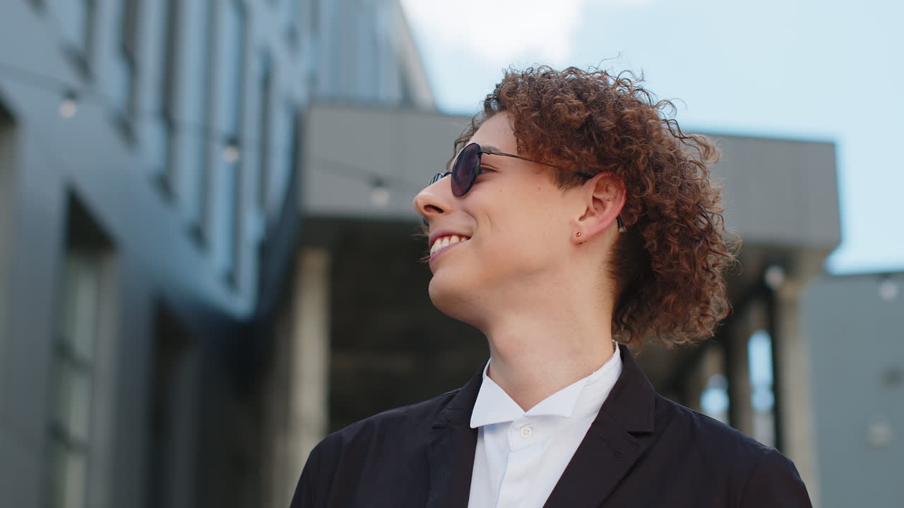Portrait in city outdoors smiling happy young businessman leader carefree company ceo in sunglasses