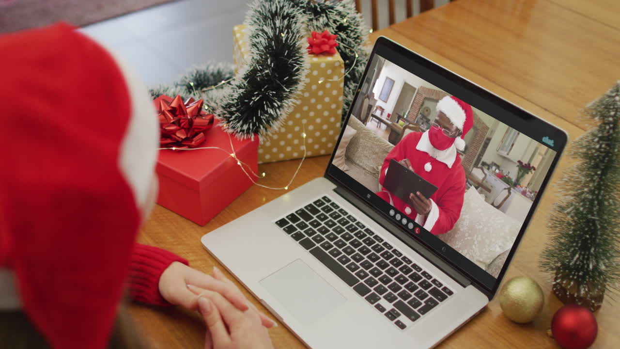 mujer caucásica en videollamada con santa claus en tiempo de navidad