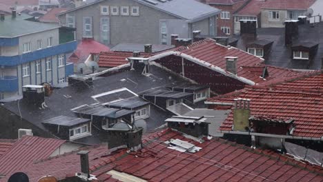 aerial view of rooftops in a city during a snowstorm