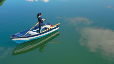 woman on the boat catches a fish on spinning in norway.