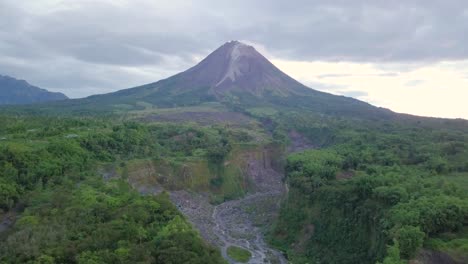 Vista-Aérea-De-Mostrar-La-Pendiente-Del-Volcán-Merapi-En-Indonesia-Y-El-Camino-De-Lava-Seca-Durante-Las-Nubes-En-El-Cielo---Bego-Pendem,-Indonesia