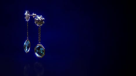 shining golden eardrops with blue topaz jewels rotate, fictive - loop video