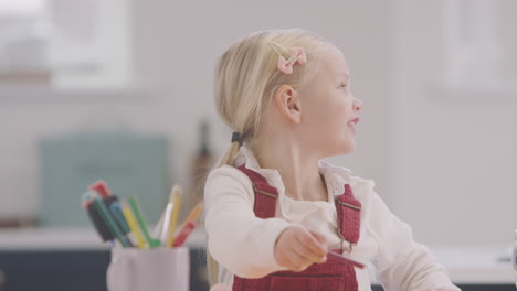 Mother-With-Daughter-At-Home-Doing-Craft-And-Drawing-Picture-In-Kitchen