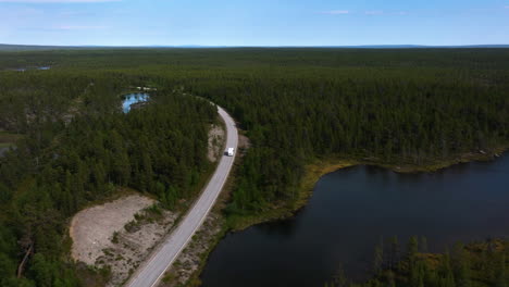 Drone-Rastreando-Una-Autocaravana-Conduciendo-En-El-Desierto-De-Naatamo,-Finlandia