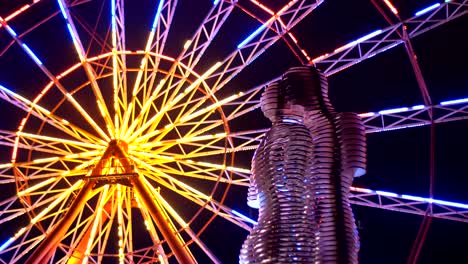 statue of ali and nino on a background ferris wheel at night on the embankment of batumi, georgia