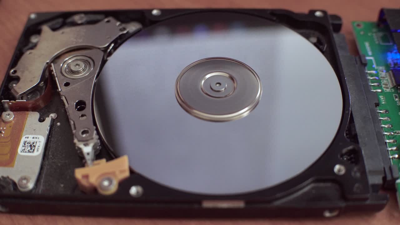 hard disk is lying on table, blinking and spinning disk. Work of hacked