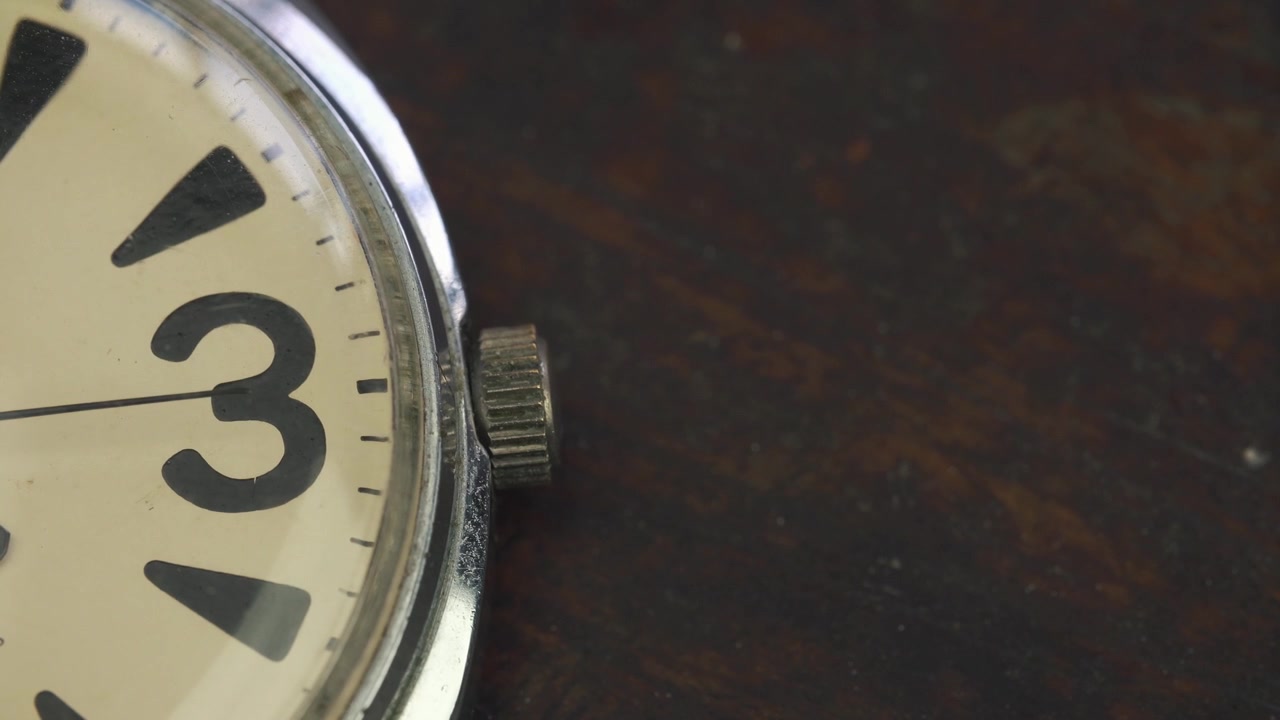 Old Watch Ticking with Second Hand Movement on Wooden Background