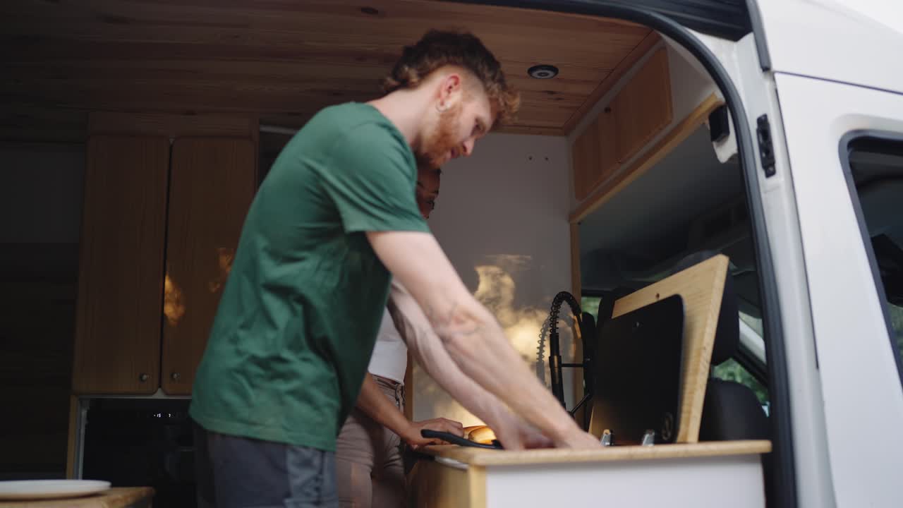 Couple cooking in campervan