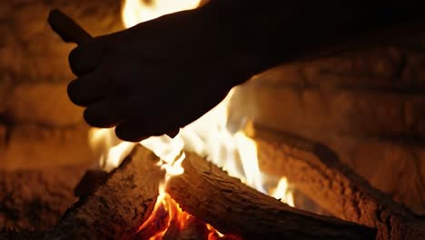 man warming his hands by a fireplace