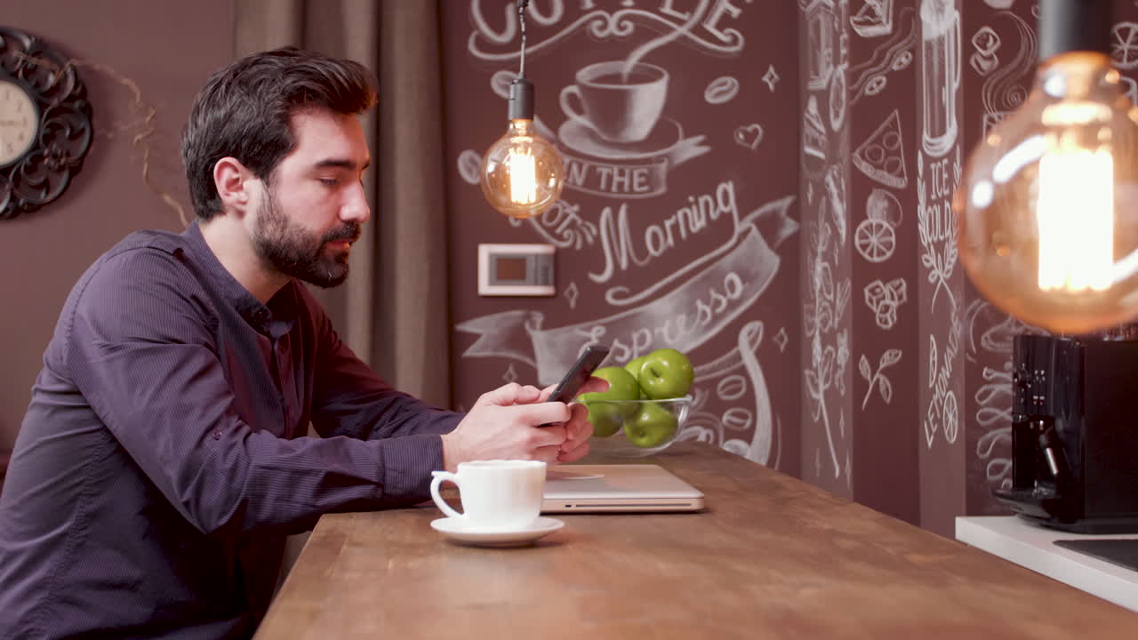 hombre que usa el teléfono inteligente en un café