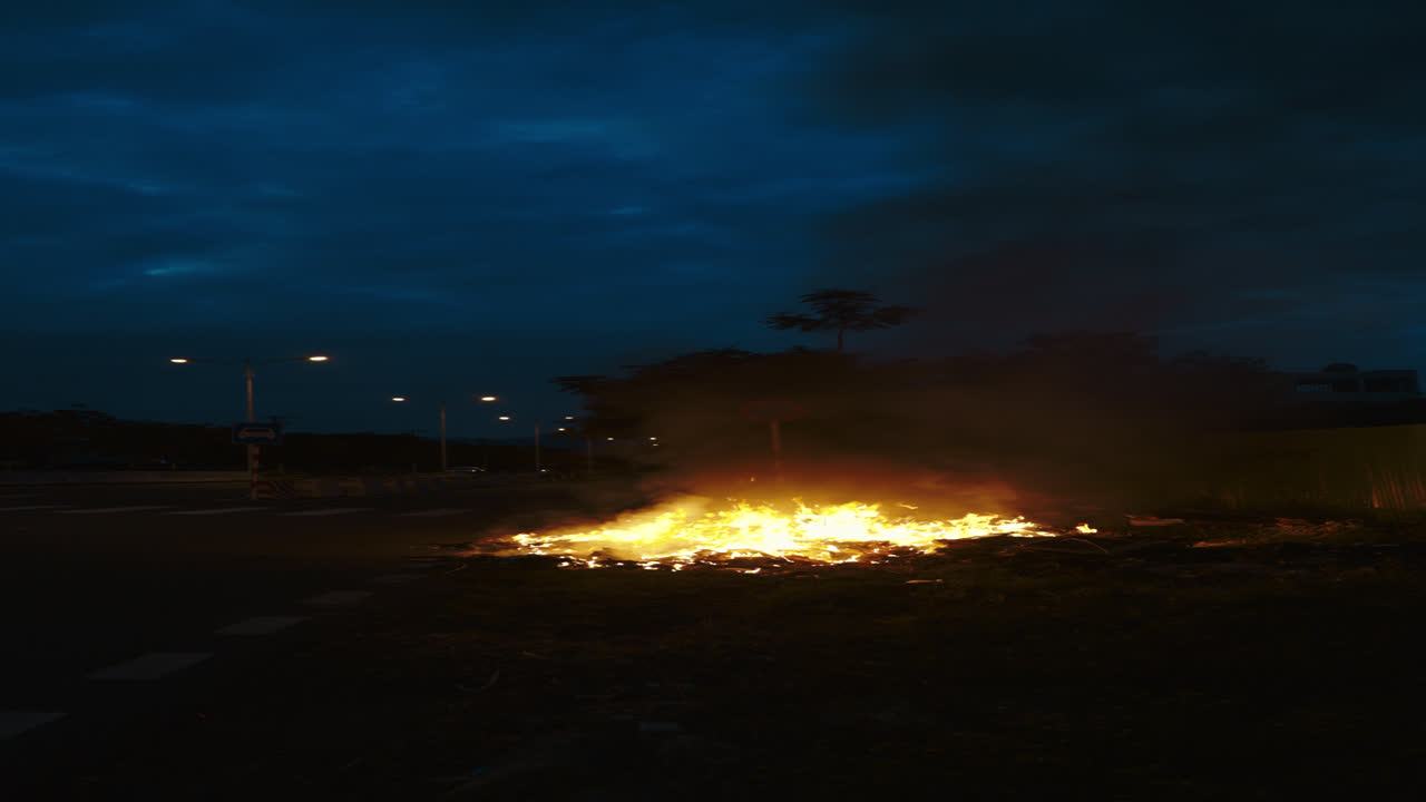 Large Fire Burning on Roadside at Night