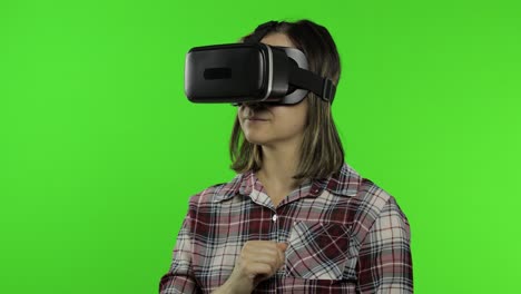 girl using vr app helmet to play simulation game. slide gestures. watching virtual reality 3d video