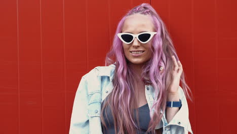 mujer con cabello rosa y gafas de sol