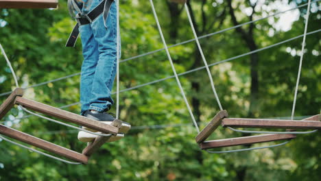 the boy is stuck on a rope obstacle can not make a step overcome the fear concept