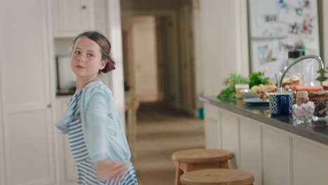 happy teenage girl dancing in kitchen having fun weekend celebrating at home with funny dance moves enjoying playful freedom