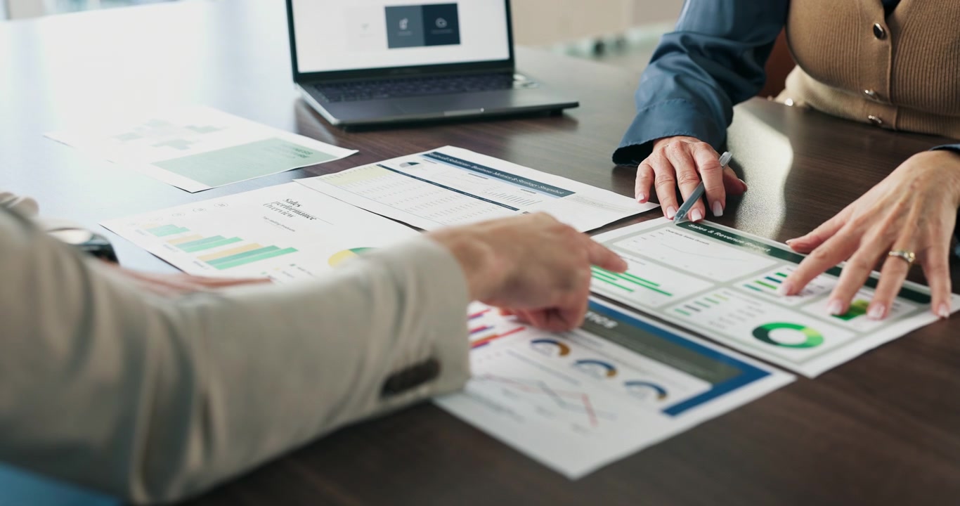 Professionisti che analizzano grafici delle performance di vendita durante una riunione in ufficio