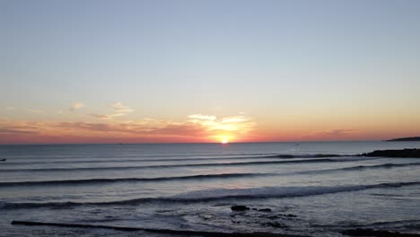 Increíble-Puesta-De-Sol-Sobre-El-Mar-Con-Surfistas-Y-Barcos