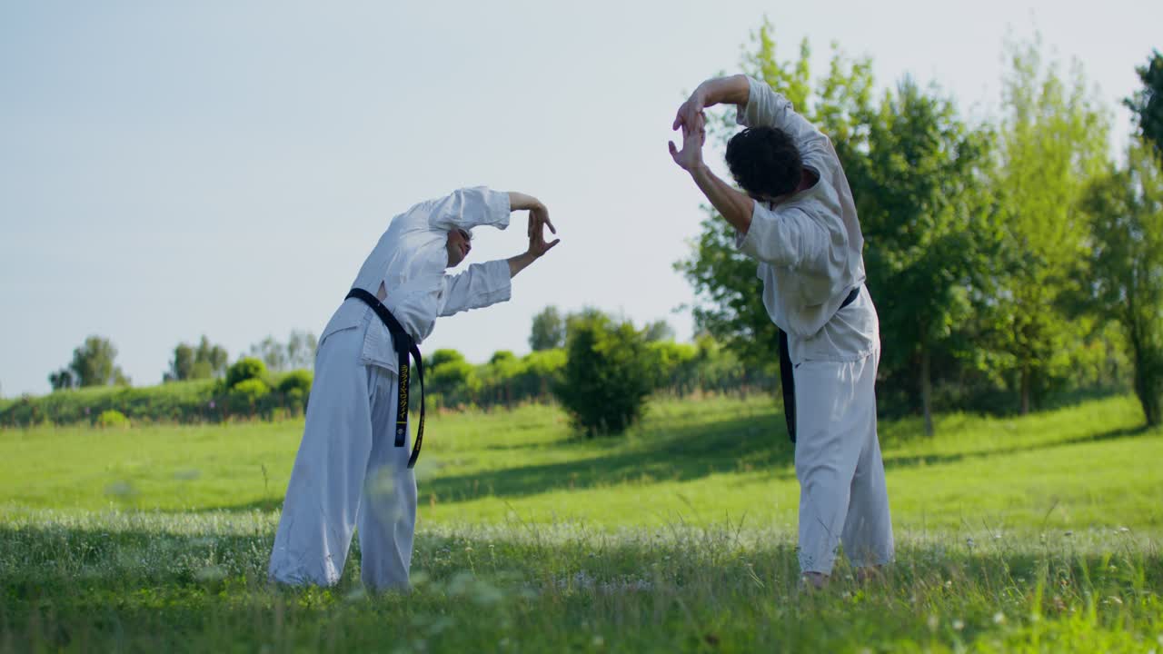 Dua pria berlatih karate di lapangan