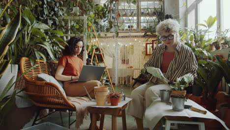 Niñas-Plantando-Flores,-Hablando-Y-Usando-Laptop