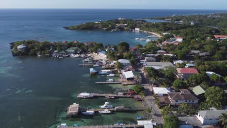 Aéreo:-Muelles-Para-Barcos-Que-Se-Adentraron-En-Aguas-Cristalinas-Del-Caribe,-Arrecifes-En-Roatán