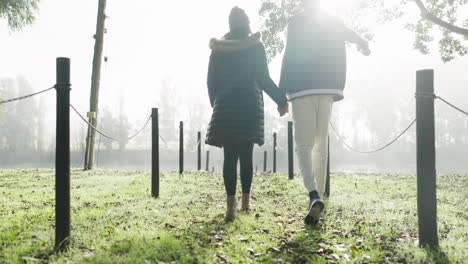 hiking, holding hands and couple back by a lake