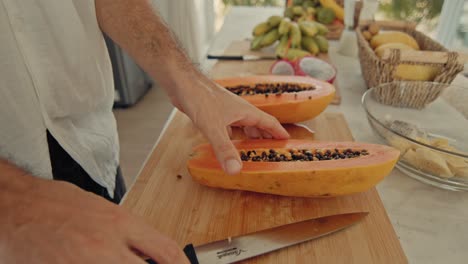 man cutting papaya