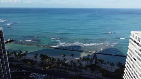 un dron cinematográfico de 4k voló entre dos hoteles de waikiki y vio las olas chocar en la playa de waikiki en oahu