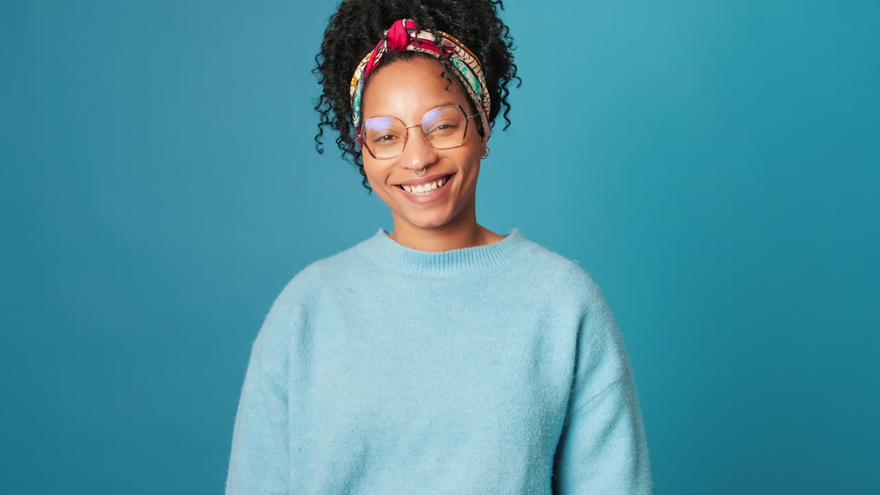 Portrait of a Smiling Young Woman with Curly Hair and Glasses