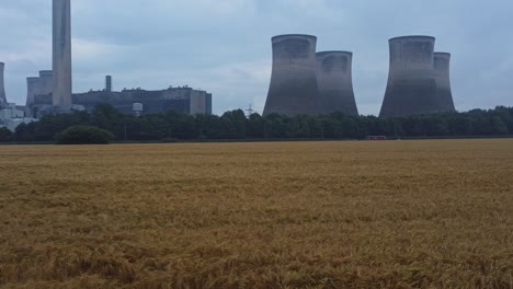 Imposanter-Konkreter-Kühlturm-Kraftwerk-Ackerland-Landschaft-Luftaufnahme-Niedrigen-Winkel-Nach-Vorne-über-Mais