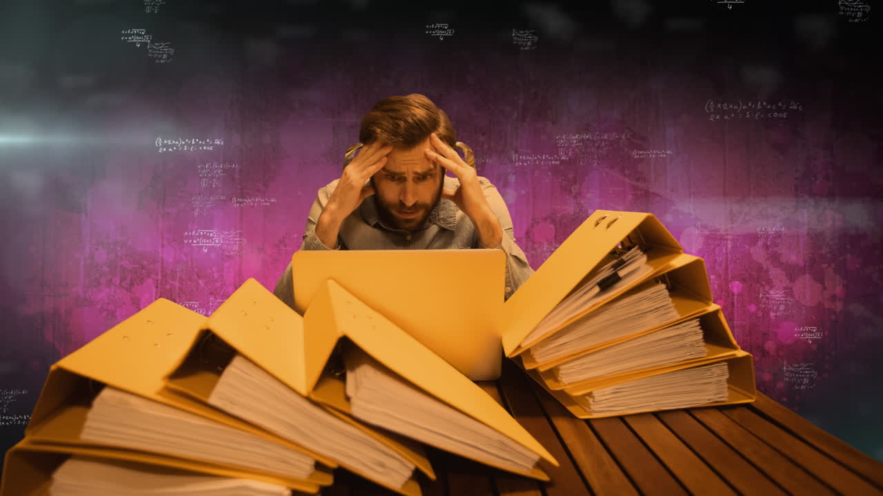 анимация разнообразных данных, движущаяся над нервным белым человеком, работающим на ноутбуке с документами на столе