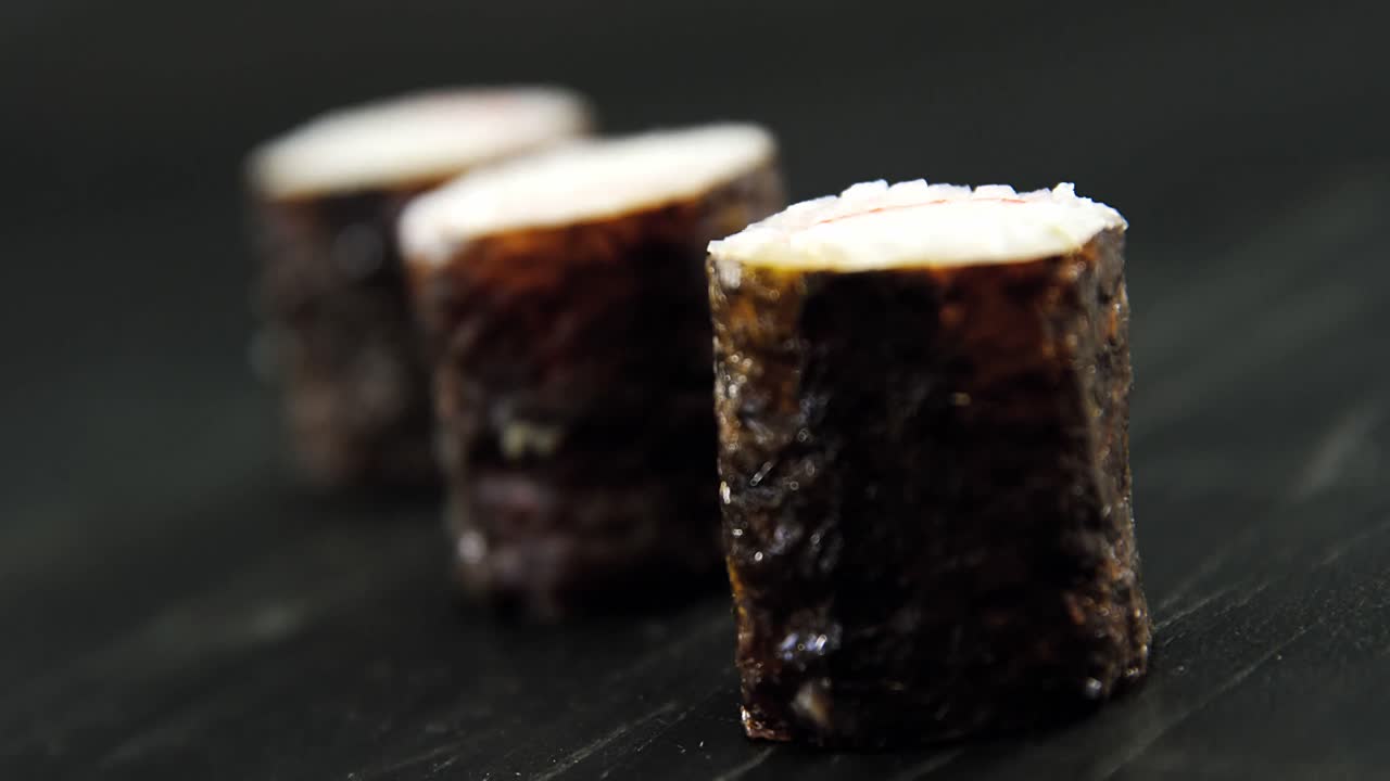 un rollo de sushi de maki servido en pizarra de piedra