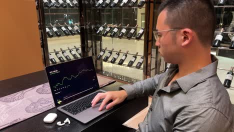 successful asian millennial man checking stock portfolio gains in his luxurious home