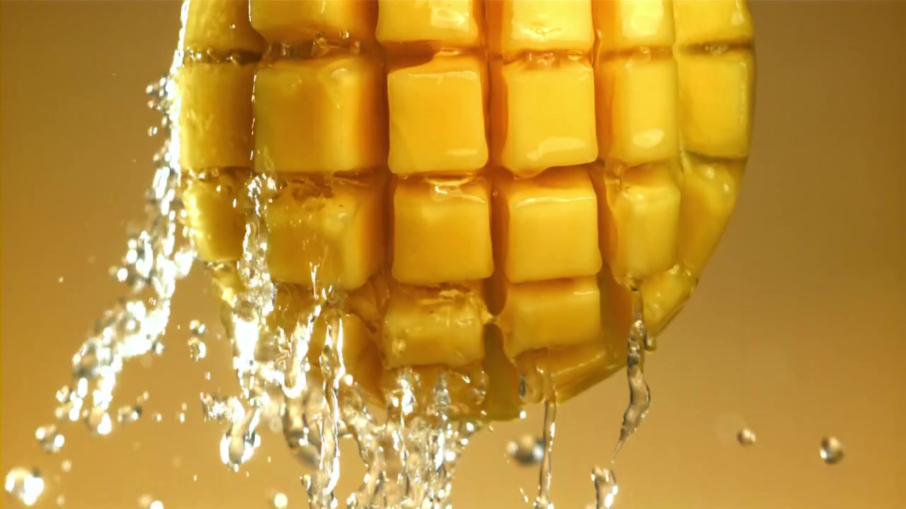 Spruzzi d'acqua rinfrescante su cubetti di mango succosi.
