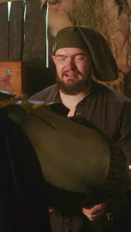 el camarero mira a un caballero bebiendo en una taberna. el propietario de una casa pública aduladora contamina la reacción del invitado a una golosina en la tienda. escena de vida medieval jugando