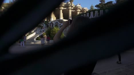 Mujer-Tomando-Fotos-Del-Famoso-Antiguo-Palacio-En-El-Parque-Guell.-Concepto-De-Turismo-De-Barcelona