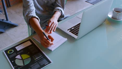 Woman writing on notepad at home 4k